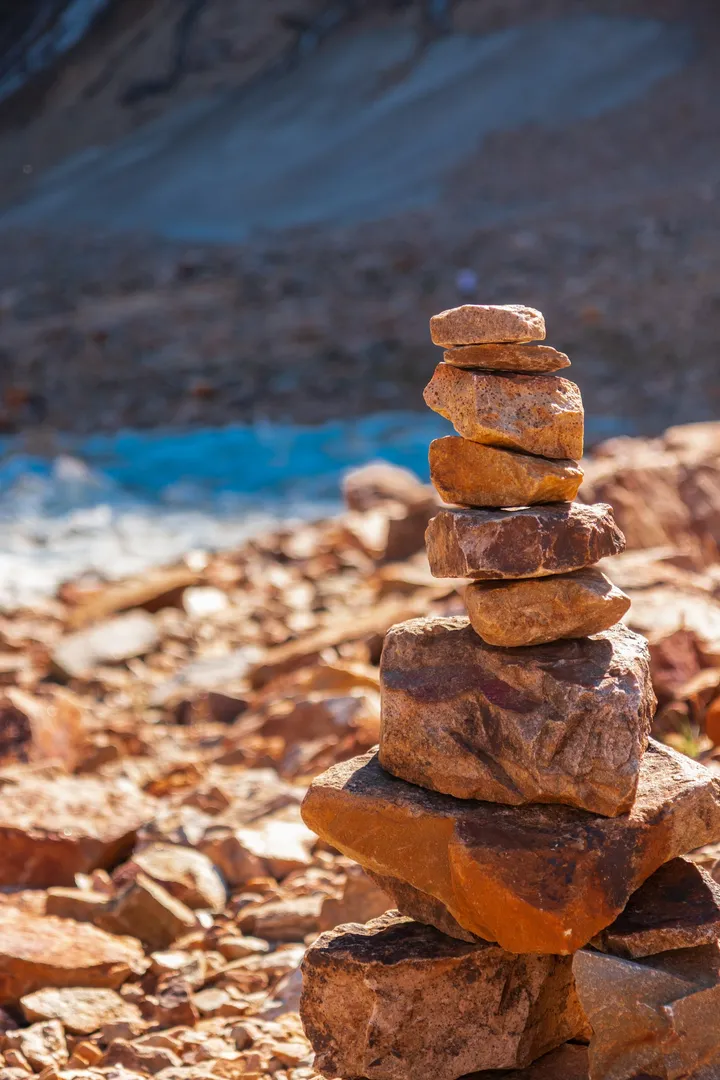 A balanced cairn of weathered stones stacked on a riverbank